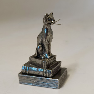 Chat en étain assis sur ses 3 livres