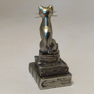Chat en étain assis sur ses 3 livres